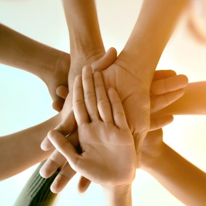 People joining hands together.